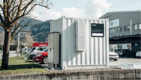 Weißer Energiecontainer auf Parkplatz vor Industriegebäude