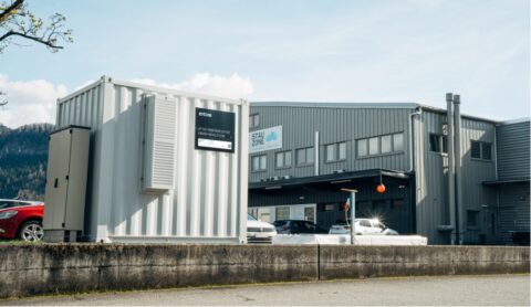 Industriegebäude mit Container und geparkten Autos