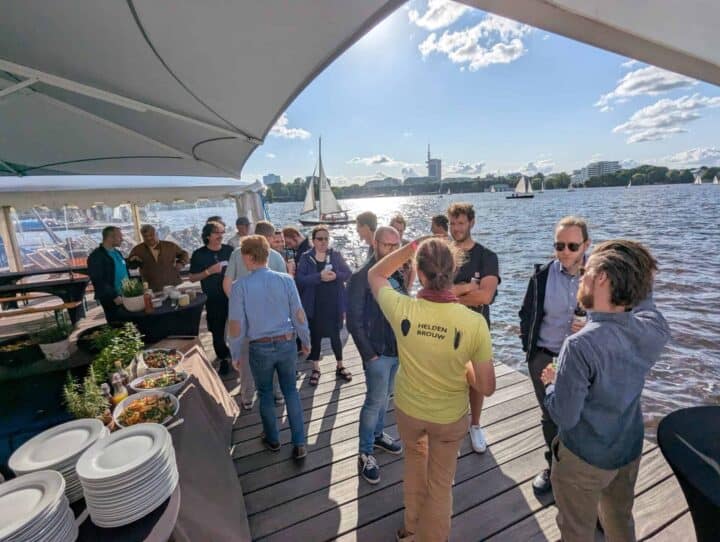 Menschen bei Sommerparty am See mit Segelbooten