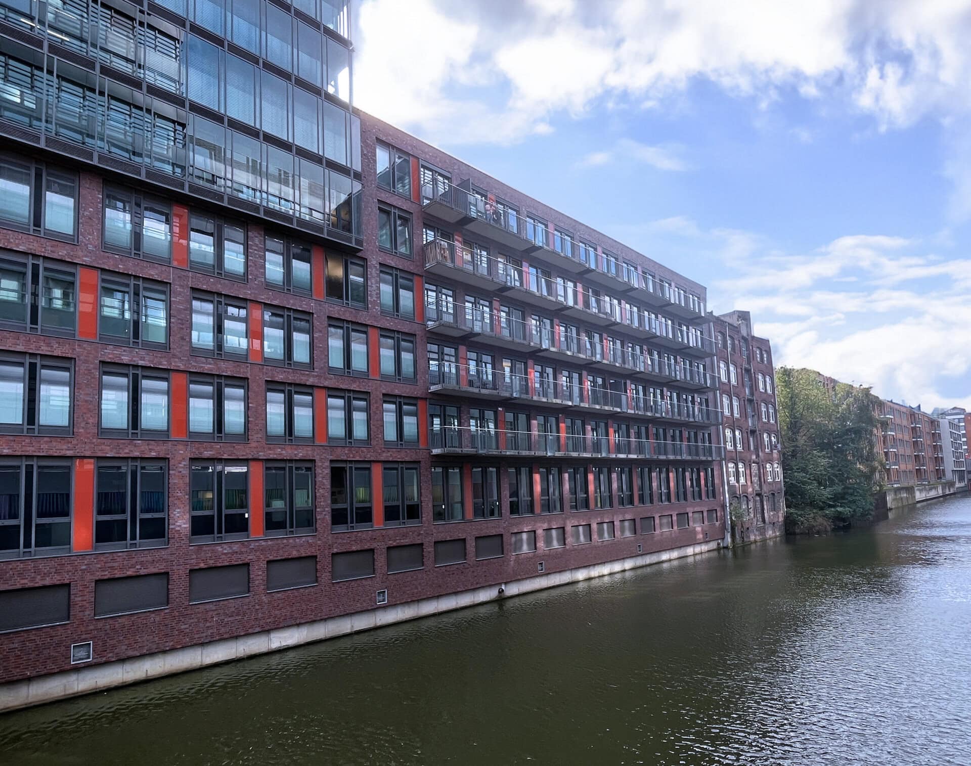 Modern brick building with balconies overlooking the canal