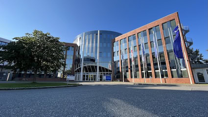 Modern administrative building with a glass facade and flags