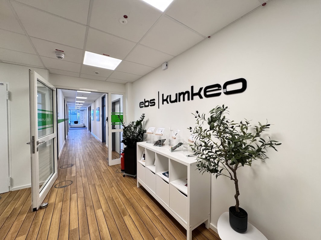 Bright office hallway with the ebs-kumkeo logo and plants