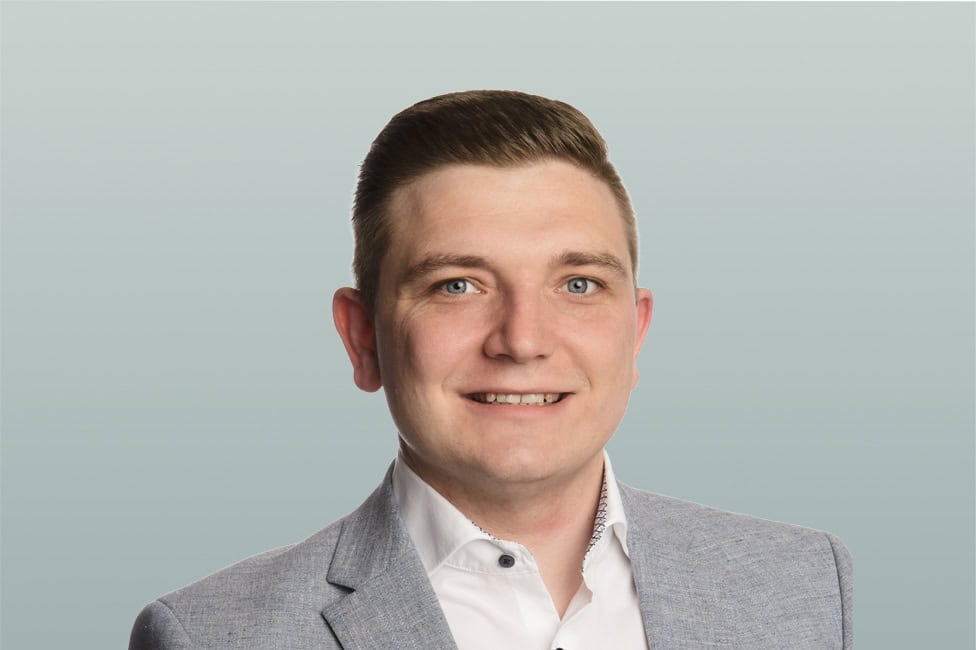 Ein professionelles Portrait von Martin Dünser in Businesskleidung vor hellem Hintergrund.
